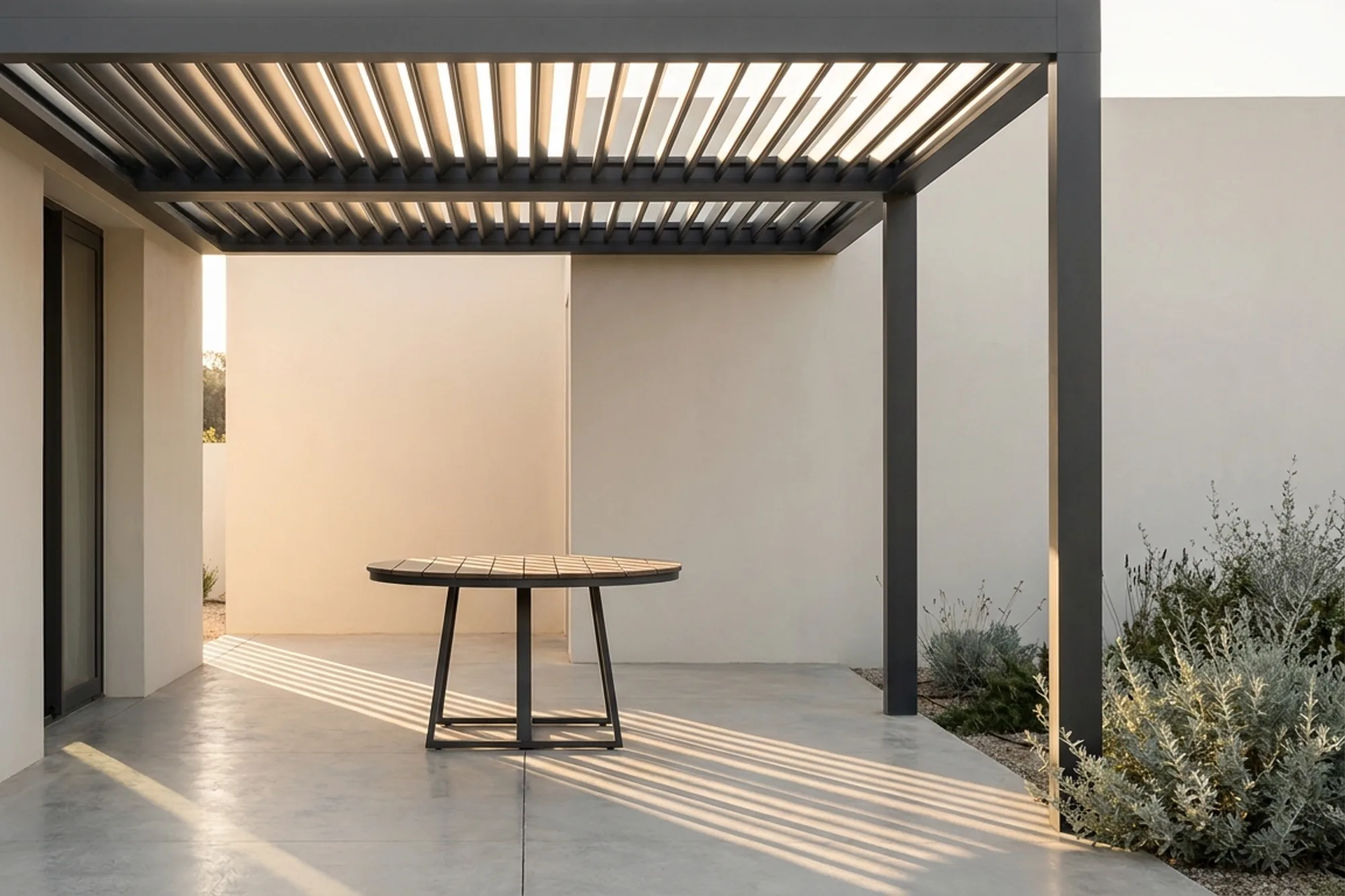 Aluminium louvre pergola casting striped shade across a paved terrace
